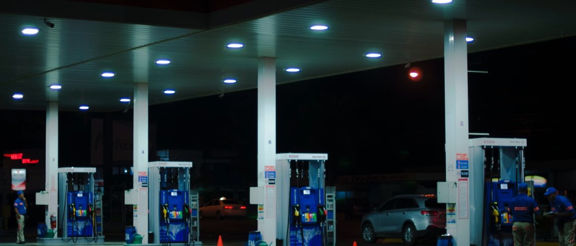 person taking a photo of blue and white gasoline station